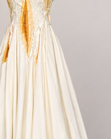 A hand-dyed ochre panel and beaded detail on a cream gown.